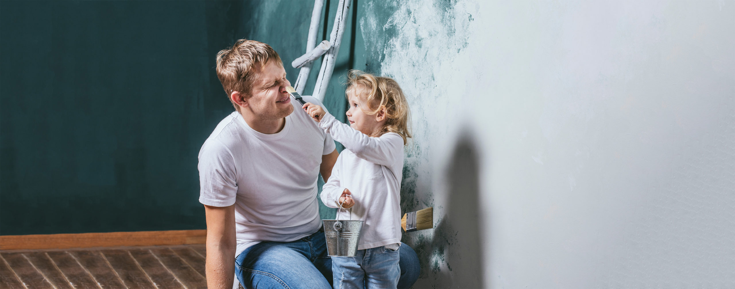 Family, happy daughter with dad doing home repair, paint walls, together with love