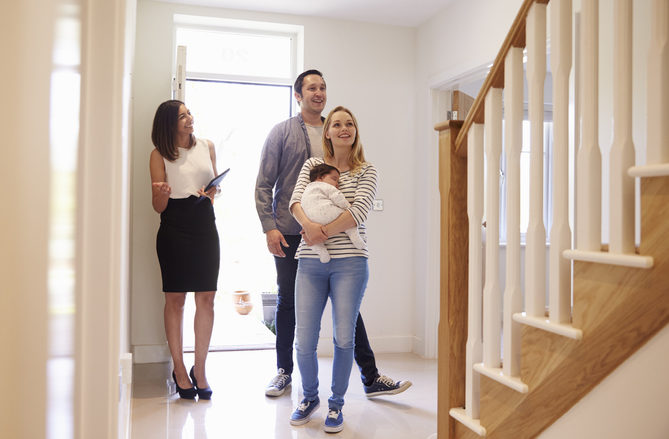 photo of real estate agent showing a home to a family